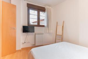 a bedroom with a white bed and a window at Vivienda Teruel Mudejar in Teruel