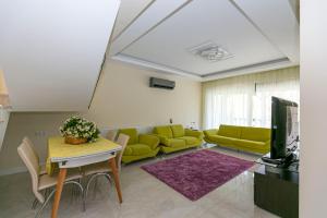 ein Wohnzimmer mit Sofa und Tisch in der Unterkunft Paradise Town Villa Estella in Belek