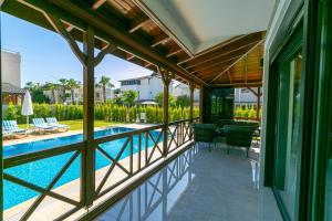 einen externen Blick auf einen Pool mit Terrasse und ein Haus in der Unterkunft Paradise Town Villa Estella in Belek