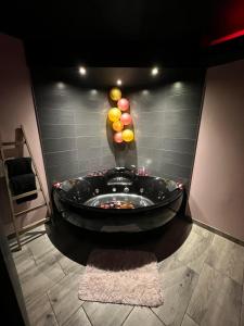 a black jacuzzi in a room with a wall at Mine d'Amour in Wallers