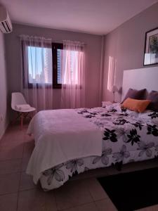 a bedroom with a large bed with a white comforter at Marfil in Posadas