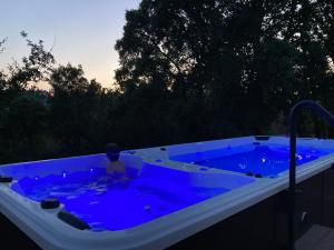 a child sitting in a jacuzzi tub with blue water at Quinta Vale de Palheiros in Santa Comba Dão