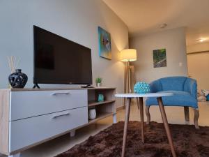 a living room with a tv and a blue chair at Marfil in Posadas