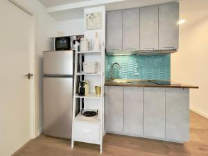 kuchnia z białymi szafkami i lodówką w obiekcie Casita del Puerto 2 w mieście Santa Pola