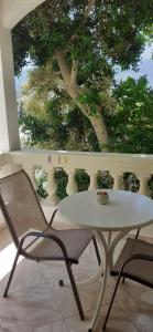 a white table and two chairs and vases at To Spiti Tis Eirinis in Poros
