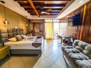 a bedroom with a bed and a couch at Hotel Boutique El Mirador in Arboletes