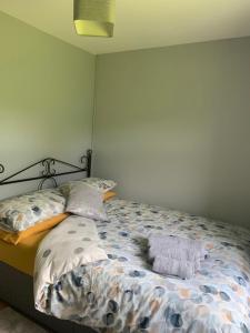een bed met een dekbed en kussens in een slaapkamer bij Church View in Omagh