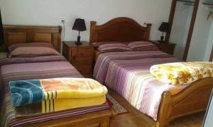 two beds sitting next to each other in a bedroom at NOUARA Appart'hotel in Chefchaouene