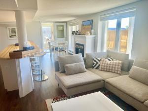 a living room with a couch and a kitchen at Auberge Tom B&B in Chelsea