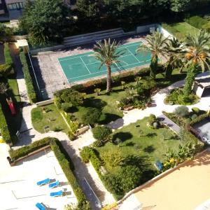 una vista aérea de una pista de tenis y palmeras en THE PENTHOUSE IN AMARILIS, en Portimão