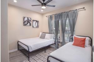 サンアントニオにあるBeautiful Fenced 3BR 2BA Near Exciting Downtownの窓のある部屋にベッドが2つある