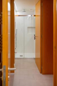 een badkamer met een douche en een glazen deur bij Carvalheira Country House - Gerês in Braga