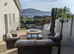 patio con sillas de mimbre y mesa en el balcón en Casa Cabanas en Cabañas