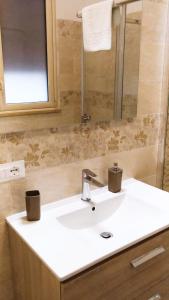 W łazience znajduje się biała umywalka i lustro. w obiekcie B&B VENTO DEL SUD w mieście Palermo