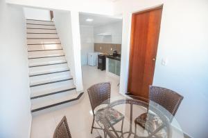 ein Esszimmer mit Glastisch und Stühlen in der Unterkunft Souza Reis Apart - Unidade 2 in São Thomé das Letras + 31 Fotos