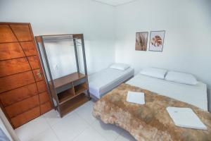 Kleines Zimmer mit 2 Betten und einer Kommode in der Unterkunft Souza Reis Apart - Unidade 2 in São Thomé das Letras