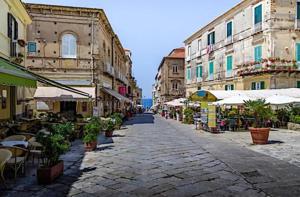 an empty street with tables and chairs and buildings at Casa Ambrosia Tropea in Tropea
