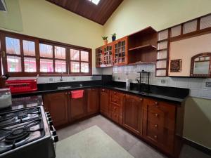 a large kitchen with wooden cabinets and black counter tops at Casa Micaela in Iquitos
