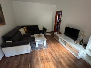 a living room with a couch and a flat screen tv at Apartmán Tatranská Kotlina in Vysoke Tatry - Tatranska Kotlina