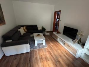 a living room with a couch and a flat screen tv at Apartmán Tatranská Kotlina in Vysoké Tatry