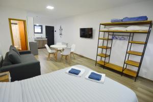 um quarto com uma cama, um sofá e uma mesa em Loft los Ñires em Ushuaia