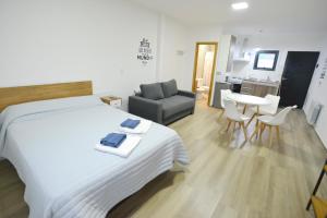 - une chambre avec un lit, un canapé et une table dans l'établissement Loft los Ñires, à Ushuaia