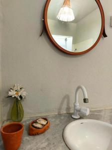 a bathroom counter with a sink and a mirror at Pousada Ziriguidüm in Caraíva