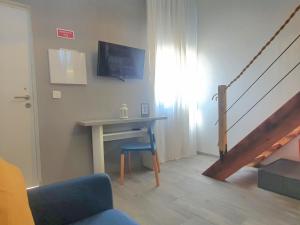 a living room with a table and a desk with a tv at Xagi House - Montargil in Montargil