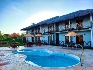 a resort with a swimming pool in front of a building at Pousada Ventos do Norte in Barra Grande