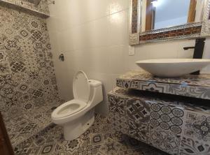 a bathroom with a toilet and a sink at Hostal Mago in Tlaxcala de Xicohténcatl