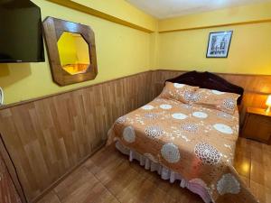 a small bedroom with a bed and a mirror at Hostal Los Salares in Antofagasta