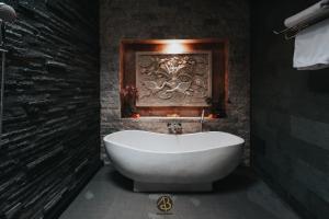 ein Bad mit einer weißen Badewanne in einem Zimmer in der Unterkunft AB UBUD LUXURY VILLA in Ubud