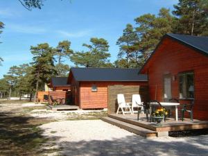 una cabaña con mesa y sillas frente a ella en Lummelunda Stugor, en Visby