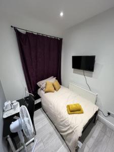 a bedroom with a bed with yellow towels on it at Welsh Homestay in Pembroke Dock