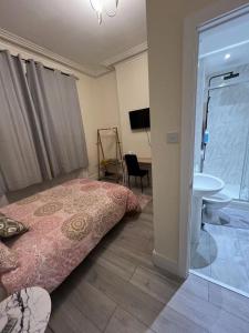 a bedroom with a bed and a bathroom with a sink at Welsh Homestay in Pembroke Dock