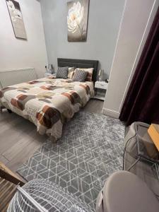 a bedroom with a bed and a rug at Welsh Homestay in Pembroke Dock