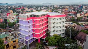 un bâtiment rose et violet dans une ville dans l'établissement MySpace Hotel @BGC, à Manille