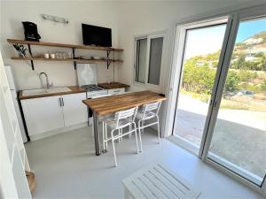 een keuken met een tafel en stoelen en een raam bij Bungalow for 6 people maximum at Saint Barth in Gustavia