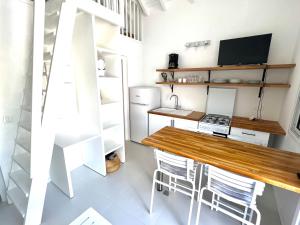 una pequeña cocina con mesa de madera y sillas en Bungalow for 6 people maximum at Saint Barth, en Gustavia