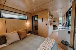 Dormitorio de una casa pequeña con cama en Blackwood Cabin, en Raglan
