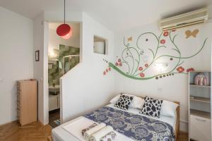 um quarto com uma cama com um mural de flores na parede em Apartment Kanemase em Sumpetar