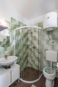 uma casa de banho com um chuveiro, um WC e um lavatório. em Apartment Kanemase em Sumpetar
