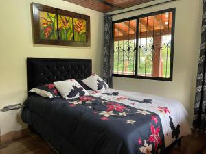 1 dormitorio con cama y ventana en Finca vista verde hostal mágico! en Medellín