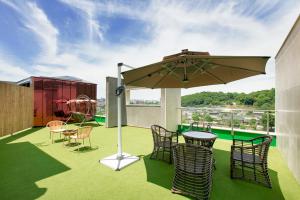 a patio with chairs and a table and an umbrella at Daon Hotel in Jeonju