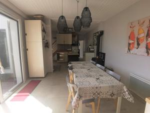 eine Küche und ein Esszimmer mit einem Tisch und Stühlen in der Unterkunft Maison La Bernerie-en-Retz, 4 pièces, 4 personnes - FR-1-612-104 in La Bernerie-en-Retz
