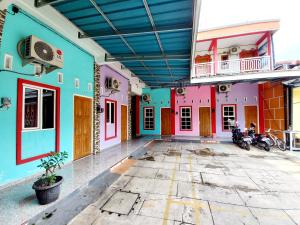 a colorful building with motorcycles parked in front of it at Harmony House Syariah near Alun Alun Pati Mitra RedDoorz in Pati