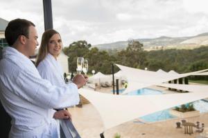 
a man standing next to a woman in front of a pool at Novotel Barossa Valley Resort in Rowland Flat

