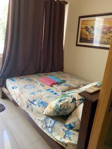 - un petit lit dans une chambre avec une table dans l'établissement Princess Place at Shell Residences, à Manille