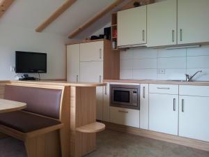 a kitchen with white cabinets and a microwave at Stübilerhof in San Giovanni in Val Aurina