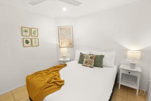un letto bianco in una camera con due lampade di Wait-a-While - Family Getaway with Heated Pool a Clifton Beach